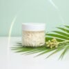 Détail de la texture fouettée d’un beurre corporel fouetté coco light, aspect crème chantilly de karité visible à travers un pot cosmétique.